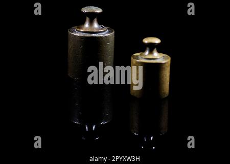 two vintage balancing weights isolated on black background Stock Photo