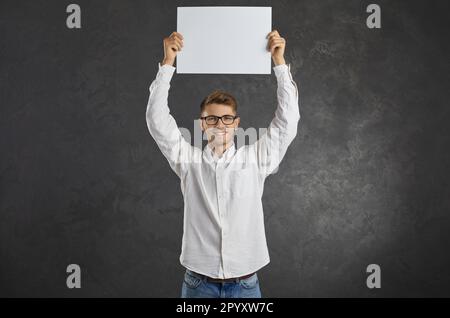 Portrait of a satisfied man expressing his opinion standing on a gray background. Stock Photo