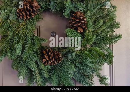 Close-up of decorative christmas wreath on the door, natural pine and fir branches and cones Stock Photo