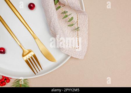 Plate with golden napkin and cutlery, minimal Christmas table setting, top view Stock Photo