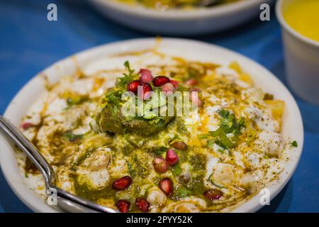 Dahi papri chaat with dahi bhalla served on a plate garnished with Sev, pomegranate seeds and other condiments. Very popular and savoury north Indian Stock Photo