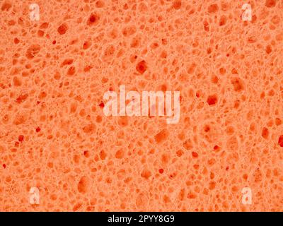 Detailed texture of the wash sponge. Orange abstract background. Stock Photo