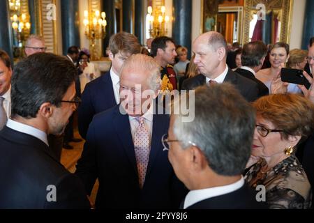 King Charles III (centre) speaks to guests during a reception at Buckingham Palace, in London, for overseas guests attending his coronation. Picture date: Friday May 5, 2023. Stock Photo