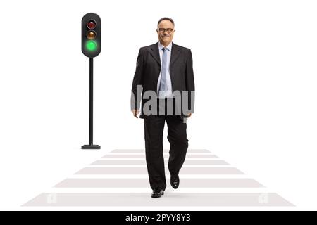 Full length portrait of a mature businessman smiling and walking at pedestrian crossing isolated on white background Stock Photo