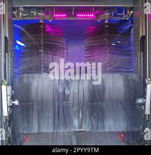 The rotating brushes of a carwash in action. The car being washed is hardly visible Stock Photo