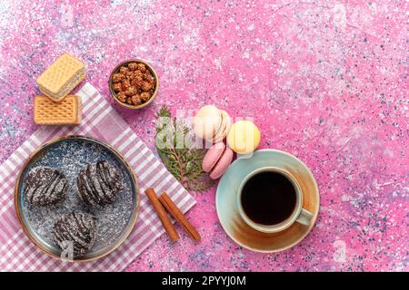 top view yummy chocolate cakes with tea and macarons on pink background cake biscuit pie sweet icing sugar Stock Photo