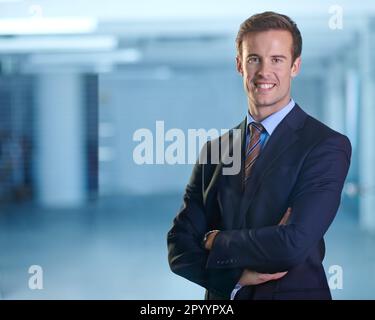 Ready to take on the corporate world. A young businessman standing and looking confidently at the camera with his arms folded. Stock Photo