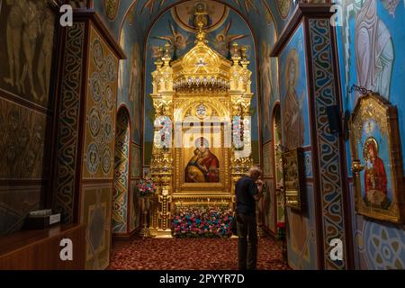 A man prays inside St. Michael's Golden-Domed Monastery of Ukrainian Orthodox Church in Kyiv on May 5, 2023 Stock Photo