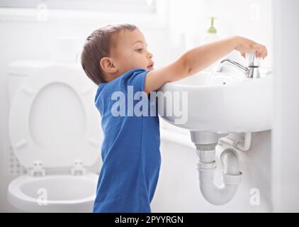 Hygienic habits. a cute young boy washing his hands in a bathroom. Stock Photo