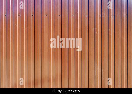 The texture of the fence made of red profiled sheet. Background. Space for text. Stock Photo