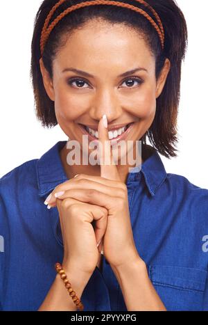 Ive got something to tell you...An attractive young woman holding a finger to her lips while isolated on a white background. Stock Photo