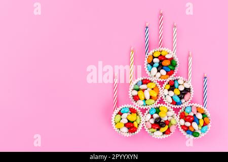 a top view colorful candies along with candles inside bowls on the pink background sweet sugar color Stock Photo
