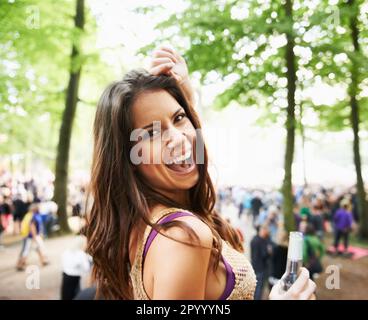 Moving to the music. A pretty young woman enjoying herself at an outdoor music festival. Stock Photo