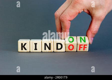 Kind on or off symbol. Businessman turns wooden cubes and changes word Kind off to Kind on. Beautiful grey table grey background. Business and kind on Stock Photo