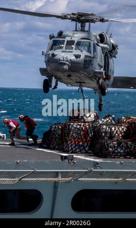 230428-N-DQ787-1065  ATLANTIC OCEAN (May 4, 2023) Personnel, assigned to the fast combat support ship USNS Supply (T-AOE-6), evacuate the flight line after hooking supplies to an MH-60S SeaHawk helicopter, assigned to the “Dragon Whales” of Helicopter Sea Combat Squadron (HSC) 28, during a replenishment-at-sea (RAS) with the amphibious assault ship USS Wasp (LHD 1), May 4, 2023. Wasp is underway conducting Basic Phase inspections and assessments. (U.S. Navy photo by Mass Communication Specialist 2nd Class David Glotzbach) Stock Photo