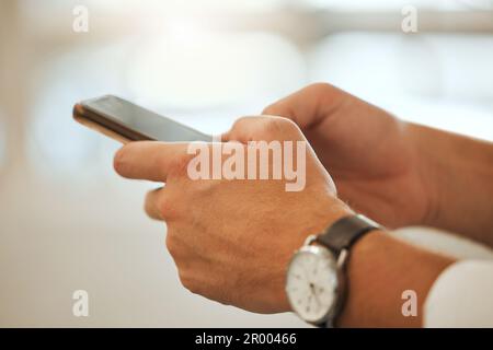 Closeup of businessman using his cellphone. Hands of an architect using a smartphone to text. Engineer using an online app. Businessman using a mobile Stock Photo