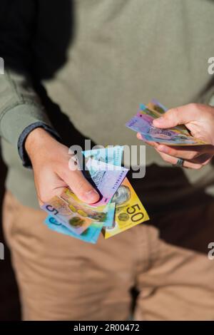 Young man holding Australian cash paying up front Stock Photo