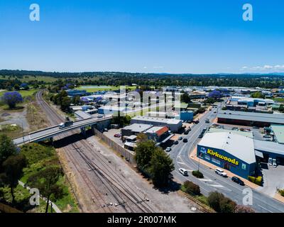 Bridge heading out of small country town in Australia over a railway with buildings along street one is Kirkwood's shop Stock Photo