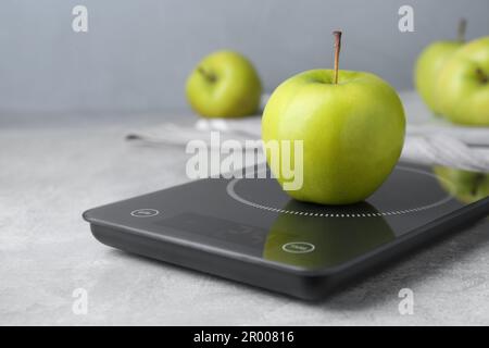 https://l450v.alamy.com/450v/2r00816/digital-kitchen-scale-with-ripe-green-apple-on-grey-table-2r00816.jpg