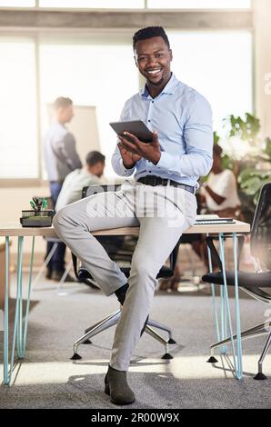 This will take us to the next level. a young businessman using his digital tablet at work. Stock Photo