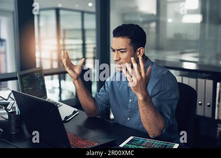 Getting your piece doesnt mean getting your peace. a young frustrated man making hopeless gestures while using a laptop in a modern office. Stock Photo