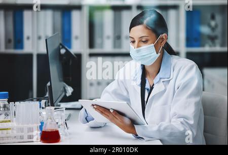 Equipment that helps keep me organised. a young female researcher using a digital tablet in a laboratory. Stock Photo