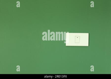White switch installed on green wall Stock Photo