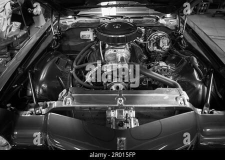 An old cheverolet with open engine hood stands in a workshop Stock Photo