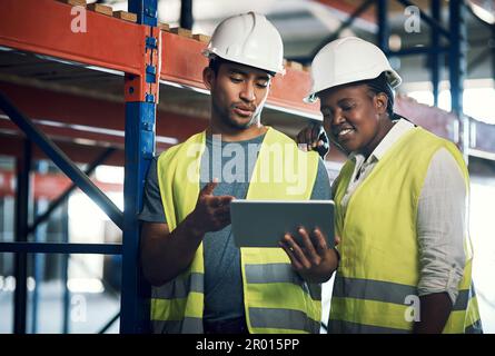 Smart planning makes for safe operations. two builders using a digital tablet while working at a construction site. Stock Photo