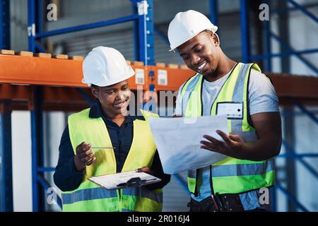 Shes the best one to ask. two young contractors standing in the warehouse and having a discussion while doing a stock-take. Stock Photo