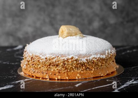Banana and cream cake. German pie. Banana and cream cake on a dark background. Stock Photo