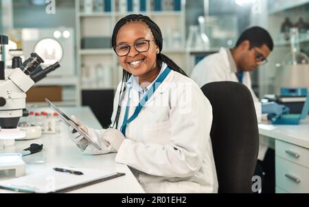 Technology is my lab assistant. Portrait of a young scientist using a digital tablet in a lab. Stock Photo