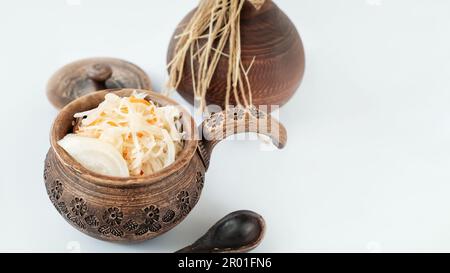 sauerkraut in clay eco-friendly dishes. Cooking homemade fermented food, the concept of healthy home nutrition. Stock Photo
