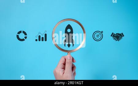 Businessman holding magnifying glass with business icon Stock Photo