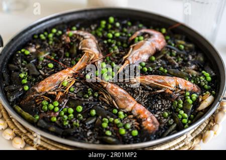 Black rice with prawns and squid, a dry rice, cooked in paella or in a ...