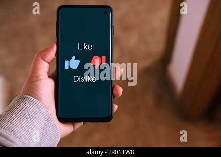 Woman use smartphone with a Like and Dislike symbols on screen. Social media concept. Feedback and review. Internet of things. Stock Photo