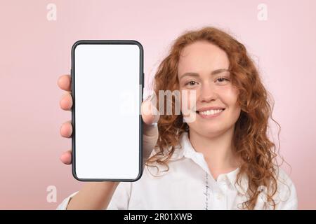 woman showing smartphone with blank white screen Stock Photo