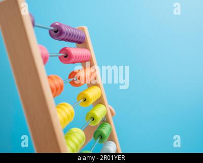 Wooden abacus on a blue background, Wooden abacus for children. Wooden abacus close-up. Stock Photo