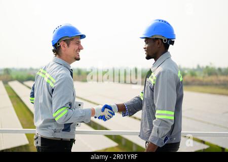 Professional engineers maintaining solar panels on solar cell farm Stock Photo