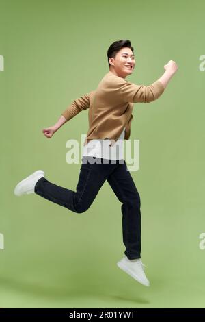 Full size photo of young happy excited crazy positive man jumping hold fists in victory Stock Photo