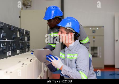 Professional engineers maintaining solar panels on solar cell farm Stock Photo