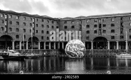 Floating Earth Artwork  and visitors at Liverpool's Albert Dock Stock Photo