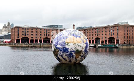 Floating Earth Artwork  and visitors at Liverpool's Albert Dock Stock Photo