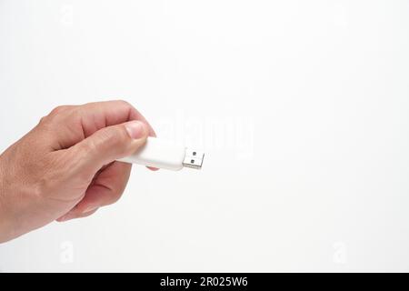 Man hand holds USB flash drive, on white background Stock Photo