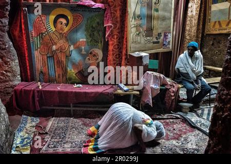 Lalibela, Ethiopia - January 7, 2018: A woman praying inside a church in Lalibela, Ethiopia. Stock Photo