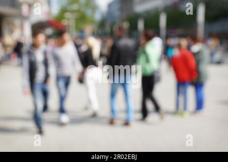 out of focus group of people walking through pedestrian area Stock Photo