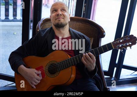 Handsome musician expresses his musical talent through acoustic guitar Stock Photo