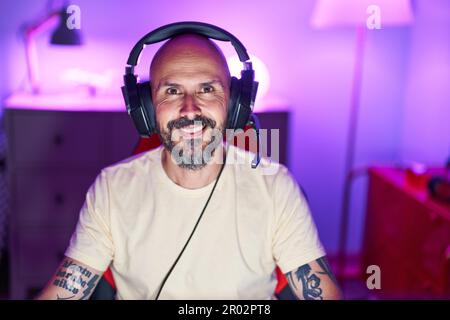Young bald man streamer smiling confident sitting with arms crossed ...