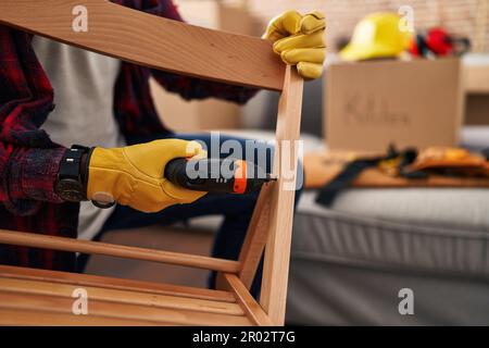 Young african american man workman repairing chair at new home Stock Photo
