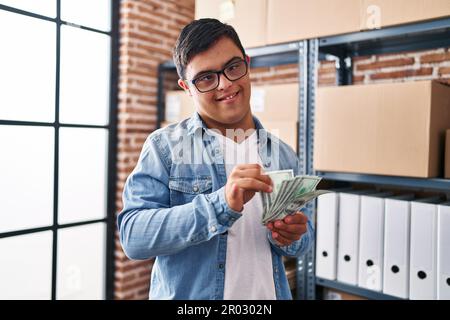 Down syndrome man ecommerce business worker counting dollars at office Stock Photo